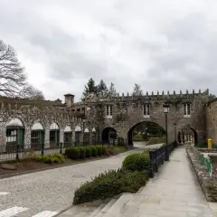 El Pazo de Coton, con su arquitectura de piedra y arcos, se alza bajo un cielo nublado, invitando a un paseo tranquilo.