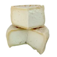 Due fette di formaggio, una sopra l'altra, con una crosta rigata. Quale preferisci: meglio formaggio di capra o pecora?