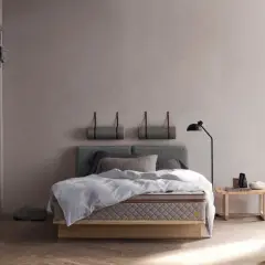 Stilvolles Schlafzimmer mit grauem Bett, minimalistischer Deko und warmem Holzboden. Tolle Schlafzimmer Ideen für Ruhe.