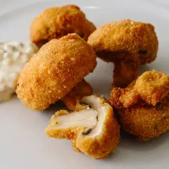Chrupiące pieczarki w panierce, idealne na przekąskę, podane z kremowym sosem.