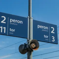 Niebieskie znaki na stacji kolejowej wskazują peron 2, tor 11 oraz peron 2, tor 3.