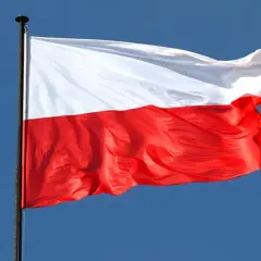 Biało-czerwona flaga Polski powiewa na wietrze. To symbol wolności, jak w piosence "Co to jest niepodległość tekst".
