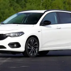 Biały Fiat Tipo kombi na tle zieleni. Wiele osób szuka takich aut, sprawdzając fiat tipo opinie.