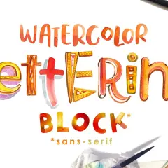 Letras de acuarela vibrantes y detalladas forman "WATERCOLOR LETTERING BLOCK". Pinceles y acuarelas sugieren el proceso creativo.