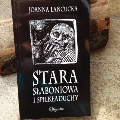 Okładka książki "Stara słaboniowa i spiekładuchy" Joanny Łańcuckiej, z mrocznym, symbolicznym rysunkiem.
