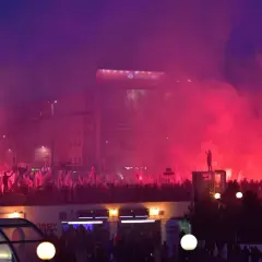 Tłum z polskimi flagami, race i dym tworzą atmosferę manifestacji. W tle widać budynki i billboard Santander. To obraz silnego nacjonalizmu.