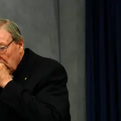 Kardinal Pell mit Brille, nachdenklich die Hand am Mund.