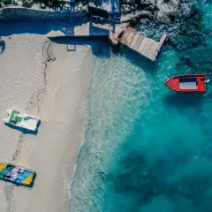 Idealne miejsce, gdzie w styczniu na wakacje: pusta plaża, łodzie czekają na wodzie, a słońce grzeje.