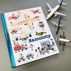 Książki o samolotach z ilustracjami różnych maszyn latających i ludzi pracujących na lotnisku. Obok leżą modele samolotów.