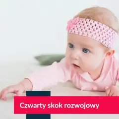 Niemowlę w różowej opasce na głowie leży na brzuchu, patrząc w bok.
