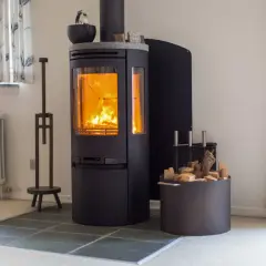 Ein moderner Holzofen mit brennendem Feuer. Hier wird gezeigt, wie funktioniert ein ofen: Holz wird verbrannt, um Wärme zu erzeugen.