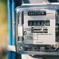 Licznik energii elektrycznej pokazuje zużycie w **kilowatogodzinach**. Widoczny jest numer seryjny i dane techniczne urządzenia.