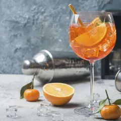 Erfrischender Aperol Spritz mit Orangenscheiben und Eiswürfeln. Die spritz zutaten der iba sind perfekt arrangiert.