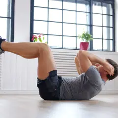 Hombre haciendo abdominales, parte de una rutina de ejercicios para bajar barriga.