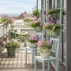 Balkon pełen kwitnących, różowych i fioletowych kwiatów w doniczkach.