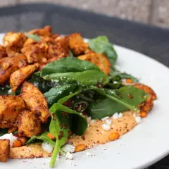 Salade colorée avec poulet épicé, épinards, quinoa et sauce crémeuse. Une alimentation trail parfaite pour l'aventure.