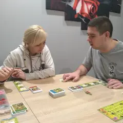 Para dowiedzieć się, jak się gra w planszówkę, obserwuje karty i planszę.