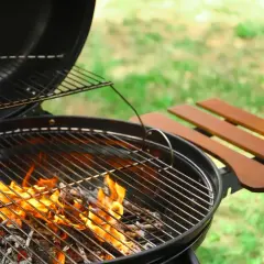 Un barbecue prêt à l'emploi, les flammes montent, signalant la bonne température bbq pour un repas en plein air.