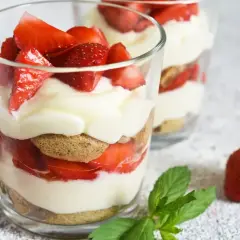 Un délicieux dessert léger aux fraises, alternant biscuits, crème onctueuse et fruits rouges frais, servi dans des verres.