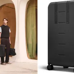 En man med snygga resväskor i modern arkitektur. En svart, robust resväska med hjul visas i detalj.