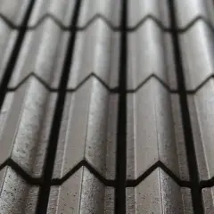 Dettaglio di tegole in cemento, un elemento essenziale per il comfort abitativo, con un pattern a onde che crea giochi di luce e ombra.