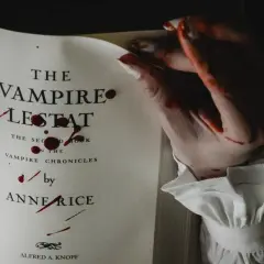 Książki o wampirach dla młodzieży, jak "Wampir Lestat" Anne Rice, z krwawymi śladami na stronach i dłoni.