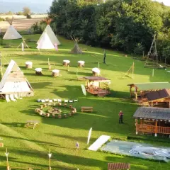 Wioska indiańska w Lubelskiem z tipi, drewnianymi chatkami i miejscem na ognisko.