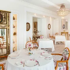 Eleganza e raffinatezza nel ristorante Don Alfonso, dove le stelle Michelin brillano in un ambiente da sogno con arredi floreali e un maestoso lampadario.