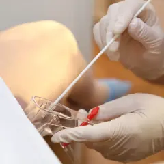 Prelievo per screening streptococco in gravidanza. Guanti medici e tampone per esame.
