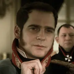 Paweł Deląg w historycznym mundurze, zamyślony. Za nim inny oficer.
