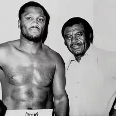 Joe Frazier, known for his impressive joe frazier height, stands with his trainer.