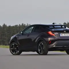 Ciemnobrązowa Toyota C-HR z czarnymi felgami na tle lasu. Czy to auto ma jakieś usterki?