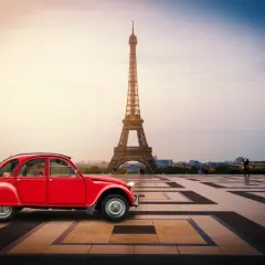 Czerwony Citroën 2CV na tle Wieży Eiffla w Paryżu.