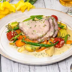 Skinkstek i ugn serverad med rotfrukter, gröna bönor och en krämig sås. En härlig vårmåltid.