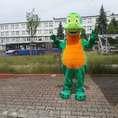 Zielony strój smoka z pomarańczowym brzuchem, stojący na chodniku.