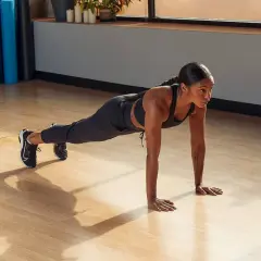 Frau in Plank-Position trainiert verschiedene plank muskelgruppen.