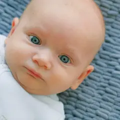 Occhi di un neonato di un blu intenso, quasi neon, che catturano lo sguardo.