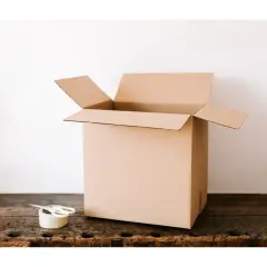 Otwarta, średnia paczka InPost gotowa do zapakowania. Obok leży taśma i nożyczki.
