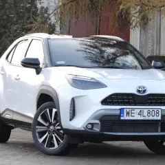 Biały Toyota Yaris Cross 2025 z czarnymi dodatkami, zaparkowany na zewnątrz.