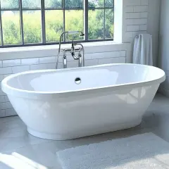 Baignoire îlot blanche, robinetterie chromée, devant une grande fenêtre avec vue sur la verdure. Une plante et des serviettes complètent cette pose baignoire semi ilot.