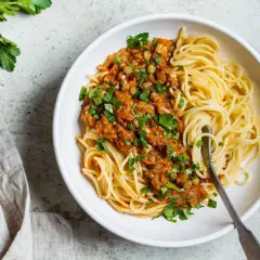 Spaghetti z sosem z soczewicy i warzyw, posypane natką. Idealne, gdy zastanawiasz się, jaki ser do spaghetti zamiast parmezanu.