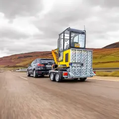 Ciężka przyczepa z koparką JCB, ciągnięta przez SUV-a, pokazuje, jaką przyczepę można ciągnąć na kat B+E.