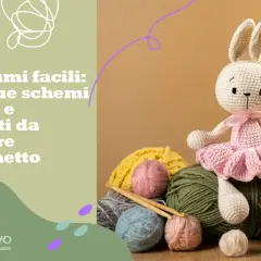 Coniglietto all'uncinetto con tutù rosa, circondato da gomitoli colorati. Scopri schemi gratis per uncinetto per bambini.