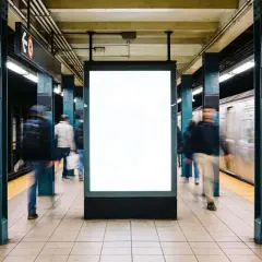 Gente se mueve rápido en el metro de Nueva York, pasando un anuncio en blanco.