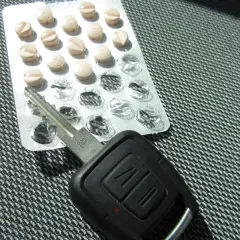 Tabletten und Autoschlüssel liegen nebeneinander. Vorsicht beim tilidin autofahren!