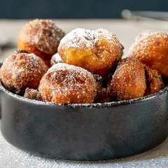 Puszyste paczki z serka homo, posypane cukrem pudrem, kuszą swoim apetycznym wyglądem.