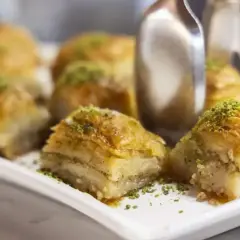 Słodka baklava, co to? Warstwy ciasta filo, orzechów i syropu, posypane pistacjami. Idealna na deser.