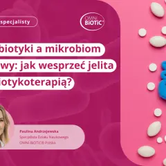 Model jelit z plasteliny otoczony tabletkami, na tle różowym i różowych bakterii.