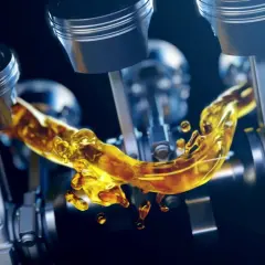 Pistones de motor con aceite dorado fluyendo, mostrando la viscosidad del aceite.