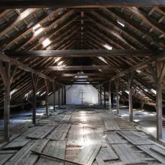 Drewniane poddasze 80m2, gotowe do adaptacji. Widok na konstrukcję dachu i deski podłogowe.